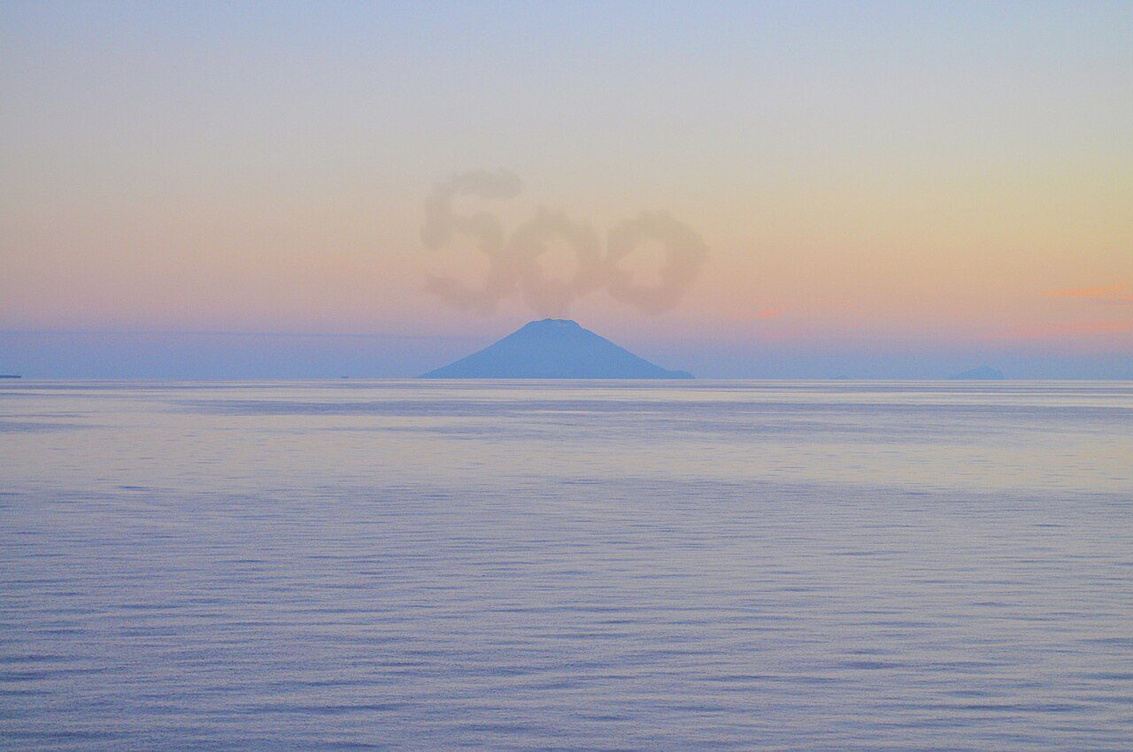 Cruceros y barcos en Messina: el volcán de Estrómboli visto desde el mar al anochecer.