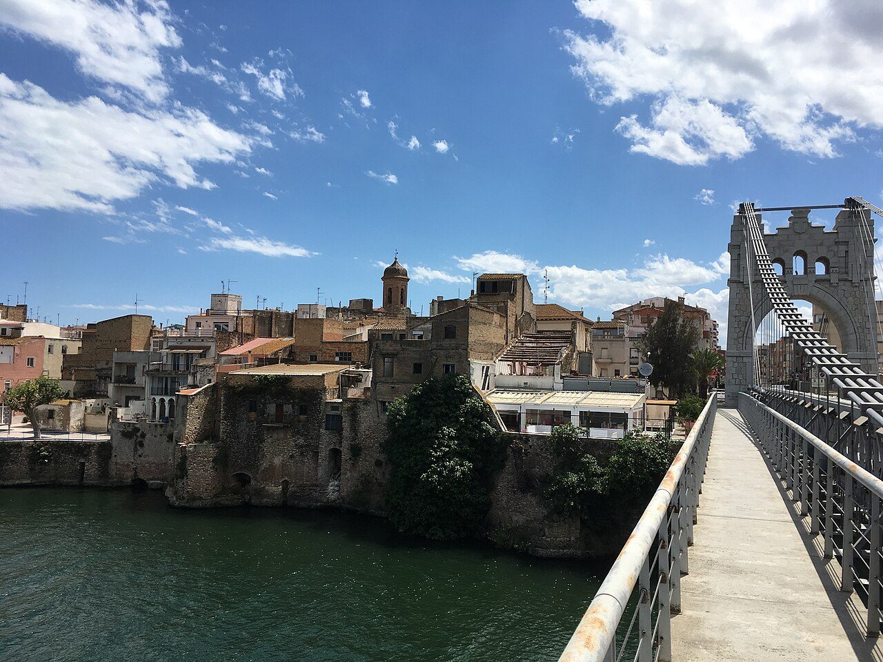 Vista del río Ebro a su paso por Amposta, con el Pont Penjat al fondo
