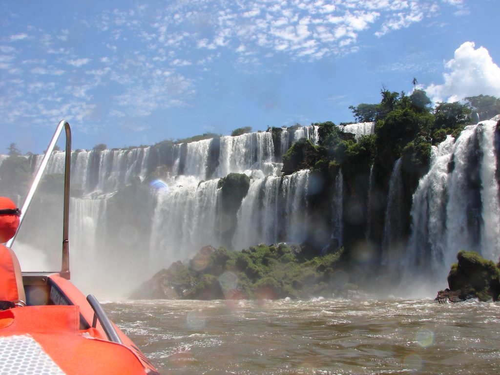 Cruceros y barcos en Puerto Iguazú al atardecer sobre el río Paraná.